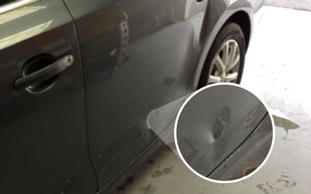 car door dent magnified close up